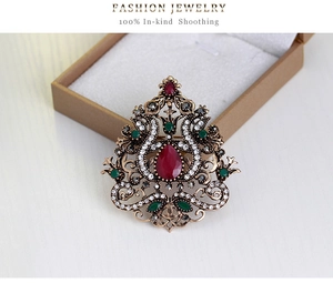 Dettaglio di spilla vintage stile palazzo con pietra rossa in una scatola da gioielli