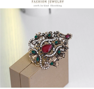 Primo piano dettagliato di una spilla vintage in stile corte con gemma rossa e strass