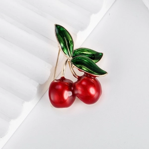Fashionable cherry fruit brooch with red enamel cherries and gold leaf details on white stand