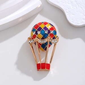 Macro shot of colorful enamel hot air balloon brooch with sparkling white rhinestones