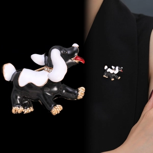 Dettaglio di una spilla a forma di cucciolo con smalto e collare di strass su blazer