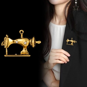 Detail of vintage sewing machine brooch with rhinestones and shiny gold finish