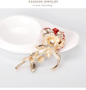 Detail of red enamel rose brooch with gold-tone stem and secure pin clasp closure