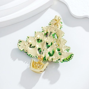 Back view of a gold-plated Christmas tree brooch with green enamel and safety pin clasp