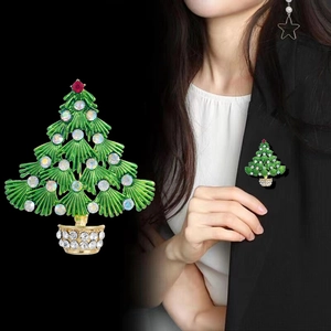 Broche sapin de Noël en émail vert et strass présentée sur mannequin et en gros plan