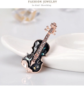 Détail de la broche violon avec émail noir, incrustations de nacre et zircons brillants