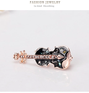 Détail de la broche violon avec émail noir, fragments de nacre et strass brillants
