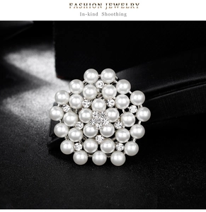 Vue détaillée de la broche en perles en forme de fleur avec strass sur fond noir