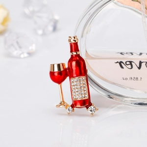 Dettaglio macro di spilla a bottiglia di vino smaltata rossa con strass e placcatura oro