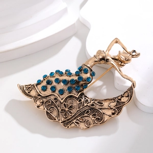 Vintage gold ethnic dancer brooch with intricate floral hollow design and blue rhinestones