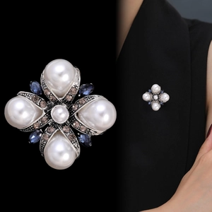 Detail of vintage Baroque cross brooch with pearls and crystals on antique silver base