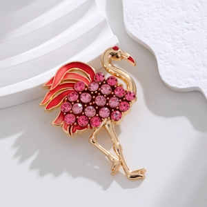 Detalle de broche flamenco con cristales rosas y esmalte rojo sobre fondo blanco puro