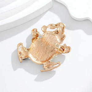 Gold plated ice skate brooch with textured finish shown from back view on white background