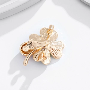 Vue arrière d'une broche trèfle à quatre feuilles dorée avec fermoir à épingle de sûreté