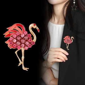 Detalle del broche de flamenco con cristales rosas y esmalte rojo en una solapa negra