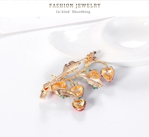 Detail of strawberry brooch pin back with secure gold clasp on white ceramic dish