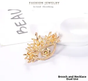 Détail d'une broche oeil vintage avec gemme jaune montrant l'épingle et l'attache au dos