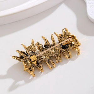 Goldfarbene Vintage-Brosche mit vier Tiersilhouetten und einem detaillierten Nadelverschluss