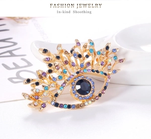 Gros plan détaillé d'une broche œil dorée vintage ornée de strass bleus et violets