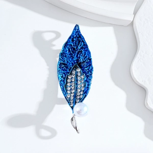 Elegant blue leaf brooch with sparkling crystals and white pearl on a clean white background