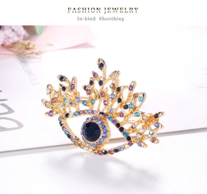 Gros plan détaillé d'une broche œil maléfique plaquée or avec des strass multicolores