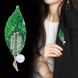 Elegant green leaf brooch with enamel details, sparkling zircons, and a large white pearl
