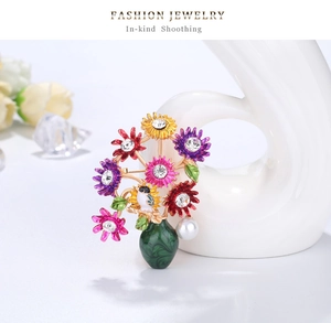 Detail of vintage daisy bouquet brooch with colorful enamel flowers and white pearl
