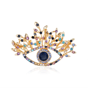 Broche œil grec rétro avec cristaux colorés et placage doré sur fond blanc pur