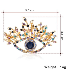 Broche œil vintage avec pierre bleue et strass multicolores sur monture dorée élégante