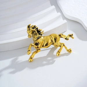 Vintage gold and black running horse brooch with detailed metallic texture and finish