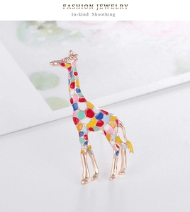 Gros plan détaillé d'une broche girafe colorée en émail avec base en métal doré rose