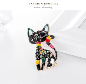 Detailed macro view of black enamel cat brooch with colorful patterns and golden outlines