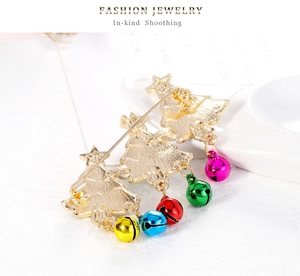 Detail view of the gold alloy Christmas brooch back with safety pin and colorful bells