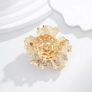 Vue arrière d'une broche tournesol dorée avec fermoir à aiguille et détails métalliques