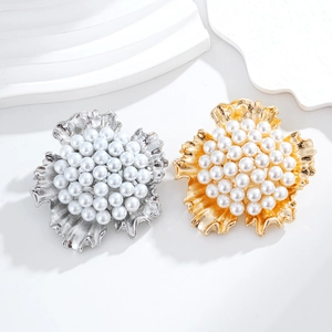 Broches florales élégantes avec perles blanches en finitions or et argent sur fond blanc