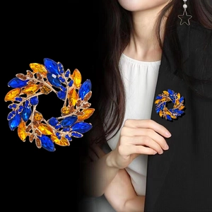 Broche couronne de feuilles dorée avec cristaux bleus et jaunes pour vestes femme