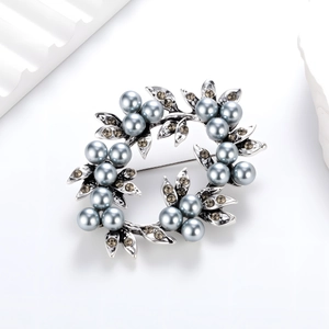Close-up of pearl wreath brooch with grey-blue pearls and leaf textures on silver base
