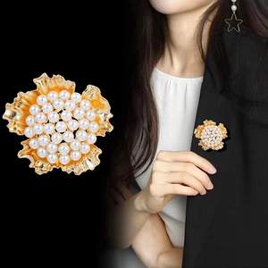 Broche fleur dorée avec perles pour femme, vue détaillée et portée sur une veste noire