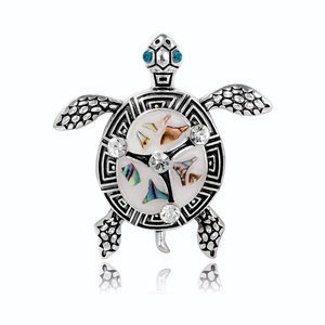 Broche tortue vintage avec incrustation de nacre et cristaux bleus sur fond blanc pur