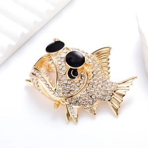 Detalle del broche de pez con cristales blancos y gafas de sol negras decorativas