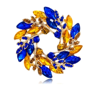 Broche couronne de feuilles élégante avec cristaux bleus et ambre sur base dorée