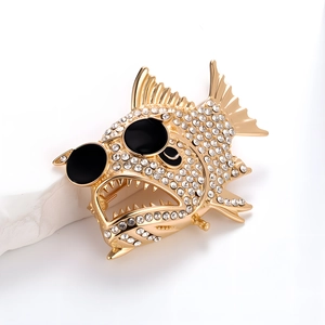 Detalle del broche de piraña creativa con cristales brillantes y gafas de sol negras