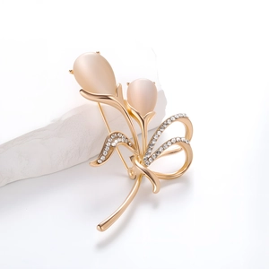 Detail van elegante tulpenbroche met roze kattenoogstenen en fonkelende zirkonia's