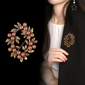 Elegant vintage gold leaf wreath brooch with pink pearls and rhinestones on a blazer