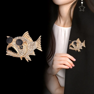 Detalle del broche de piraña con gafas en la solapa de una chaqueta negra