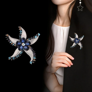 Elegante spilla a stella marina con cristalli blu su blazer nero con design marino unico