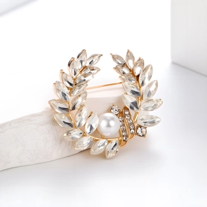 Détail d'une broche épi de blé dorée avec feuilles en cristal et une perle centrale