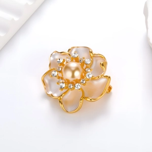 Detailed macro view of camellia brooch with champagne pearl and rhinestone petals