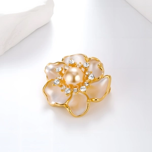 Elegant camellia brooch with champagne pearl and crystals on a white background