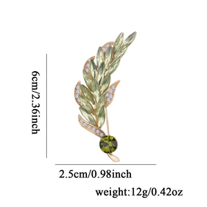 Elegant gold wheat ear brooch pin with green rhinestones and crystals on white background